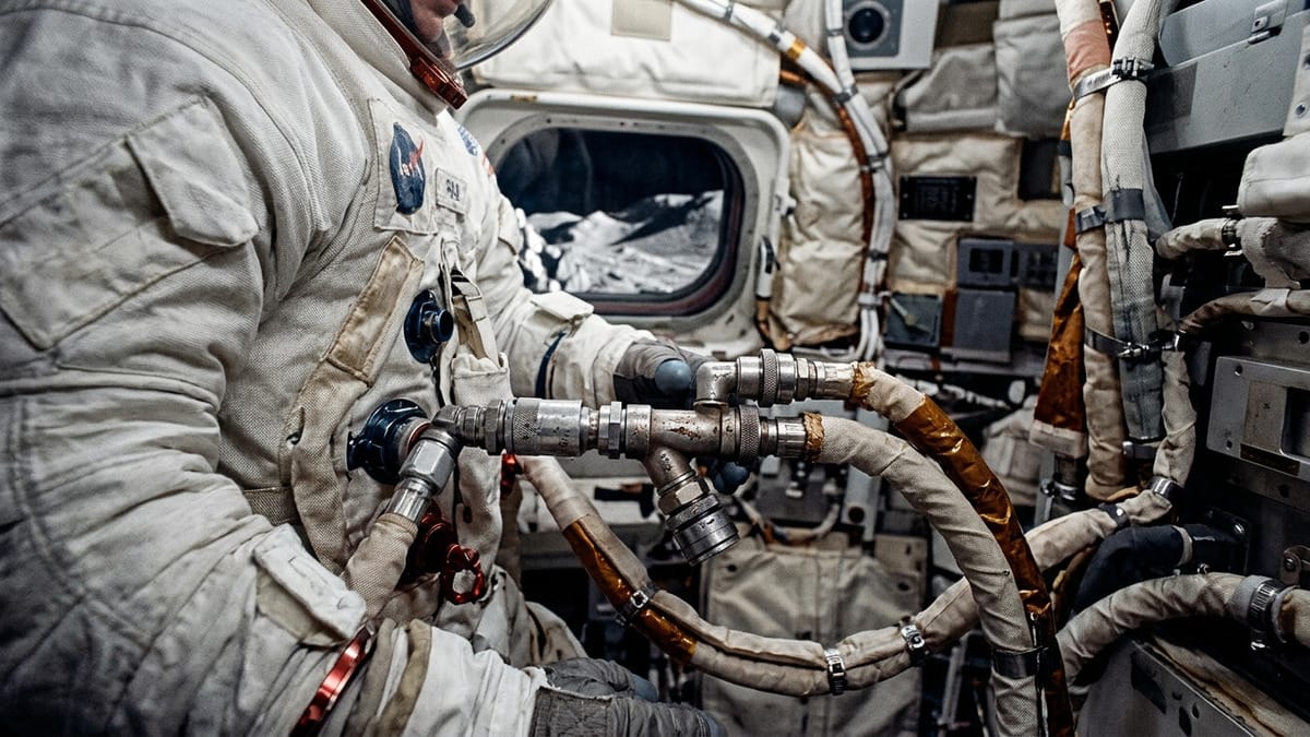 Detalle editorial de un traje espacial y un sistema de soporte vital en un entorno lunar técnico.