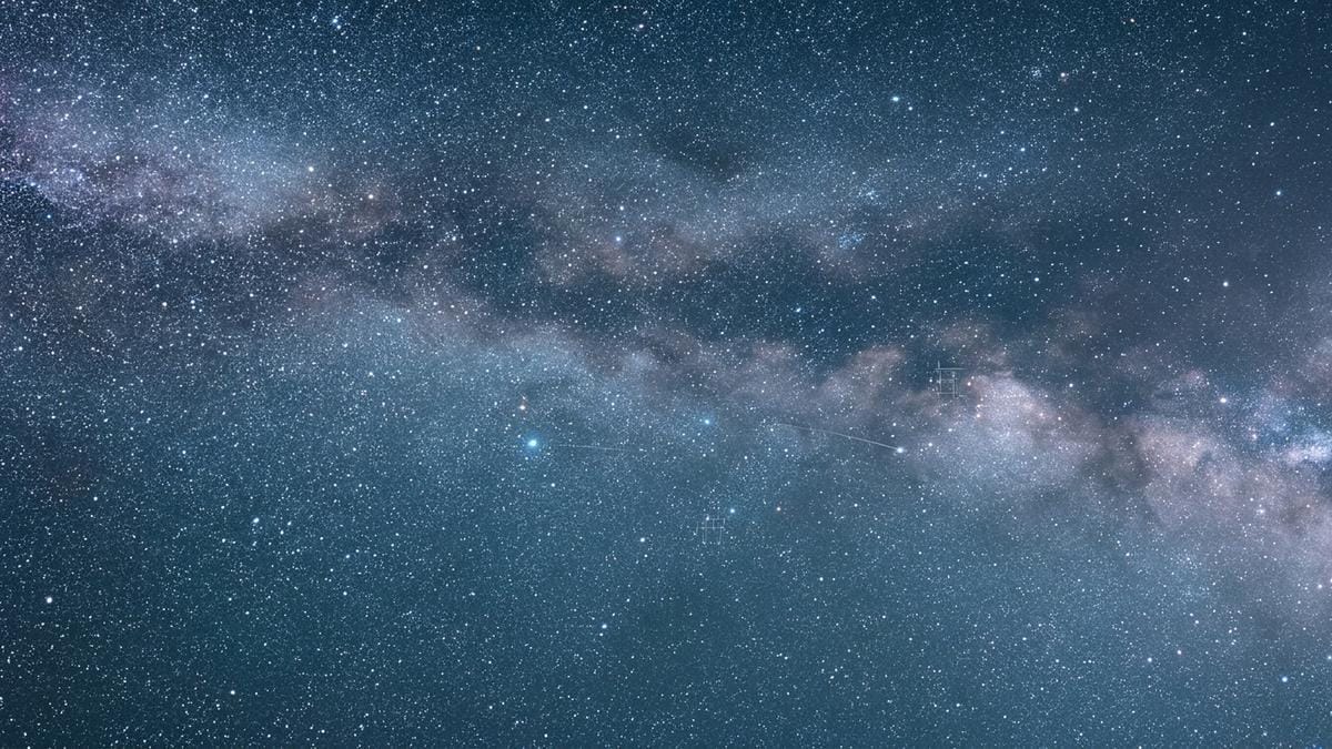 Campo estelar infrarrojo con una región de formación y trazas de polvo donde se reconstruye el posible nacimiento de un magnetar.