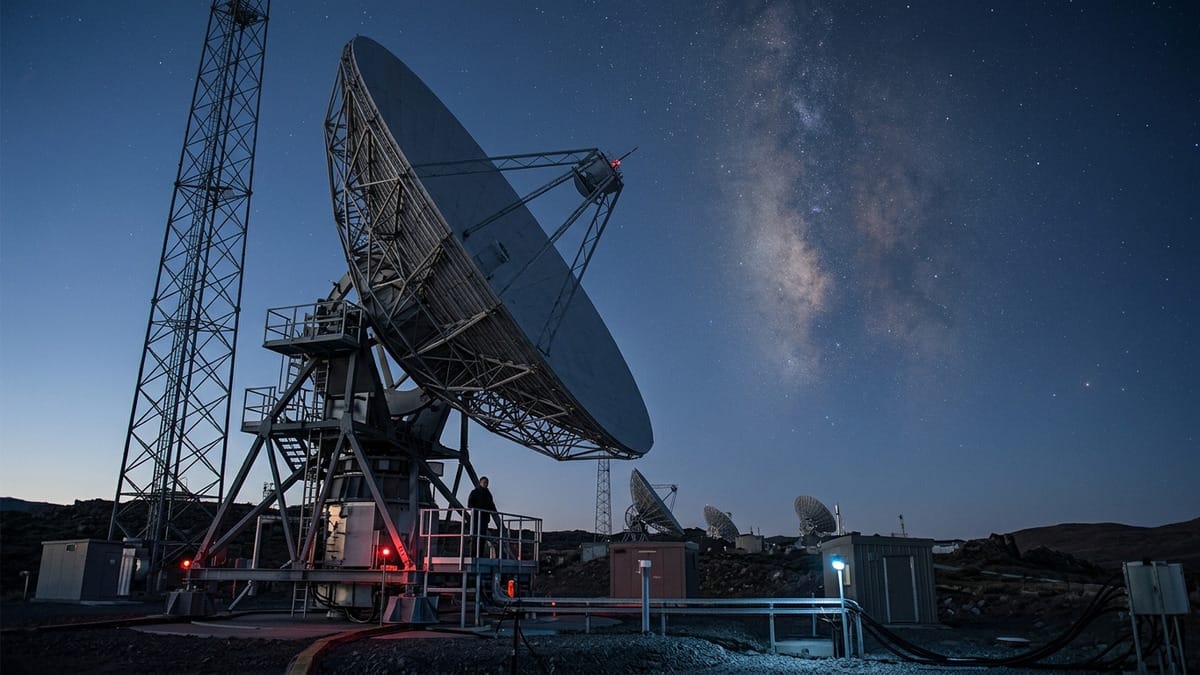 Observatorio astronómico con un gran radiotelescopio apuntando a una nube interestelar.