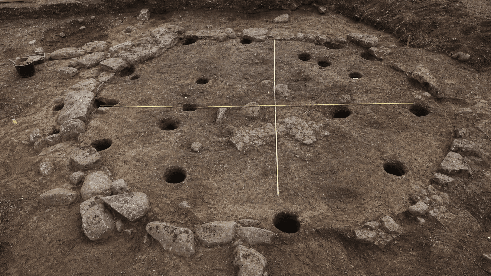 Ilustración editorial de una excavación con planta circular y agujeros de poste