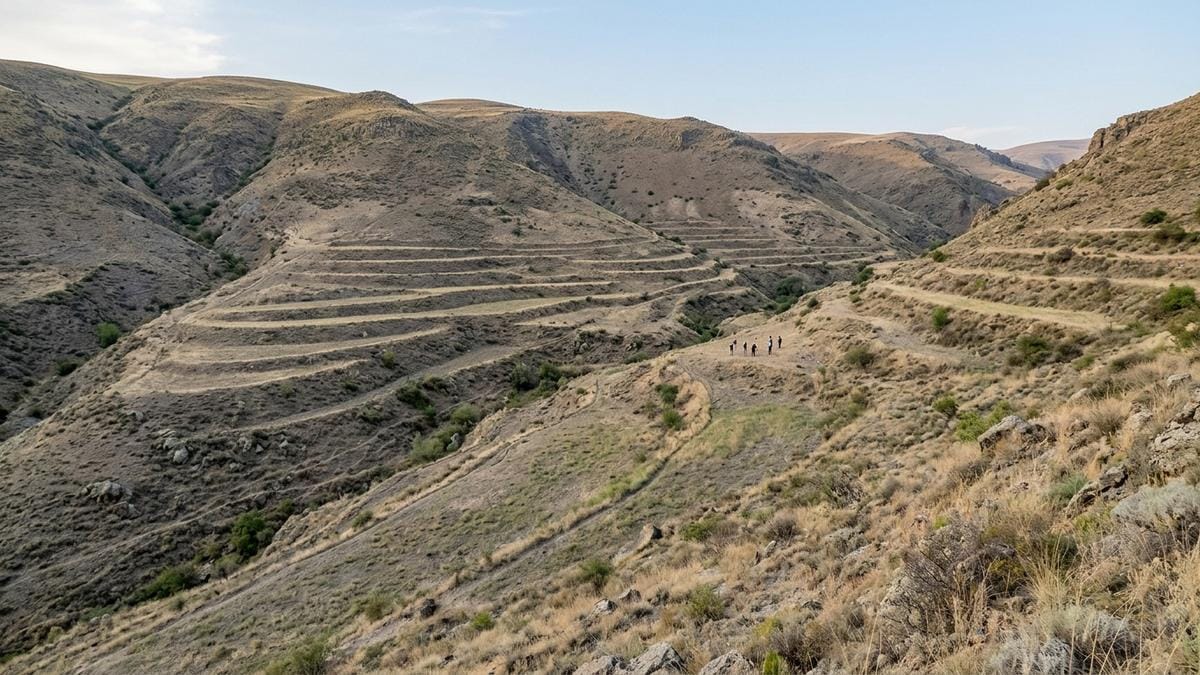 Vista amplia de un valle armenio con trazas arqueológicas de gestión del agua y terreno trabajado por antiguas conducciones