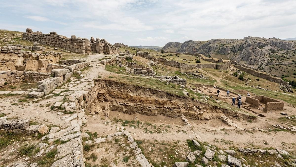 Vista lateral de las ruinas de Hattusha con capas de terreno arqueológico y excavación en curso al fondo