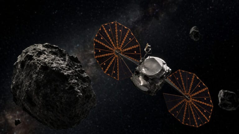 Asteroide troyano de Júpiter con el planeta al fondo y un pequeño satélite distante.