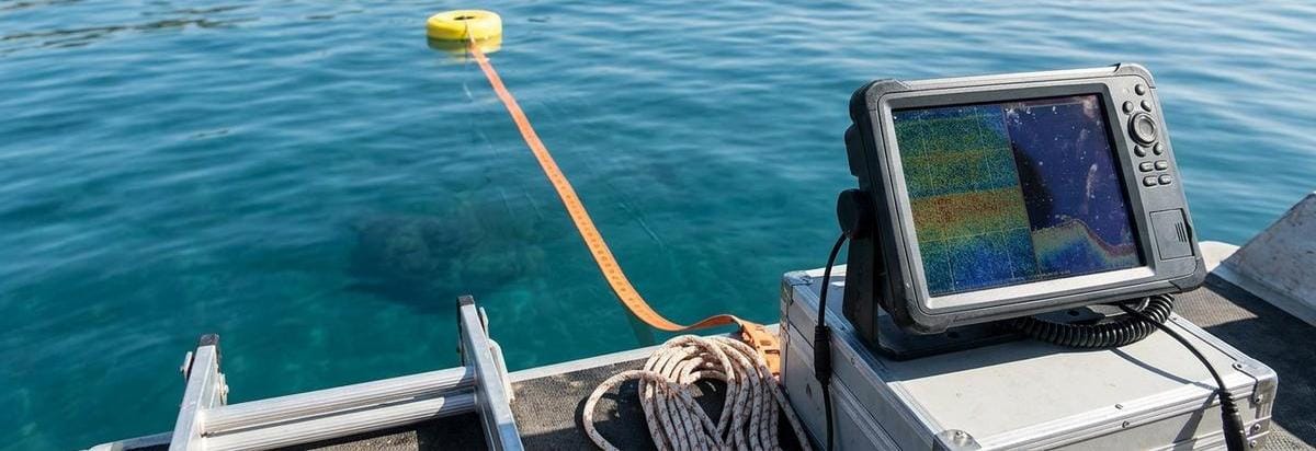 Primer plano de una prospección arqueológica subacuática con sonar y marcadores de medición frente a una anomalía del fondo marino